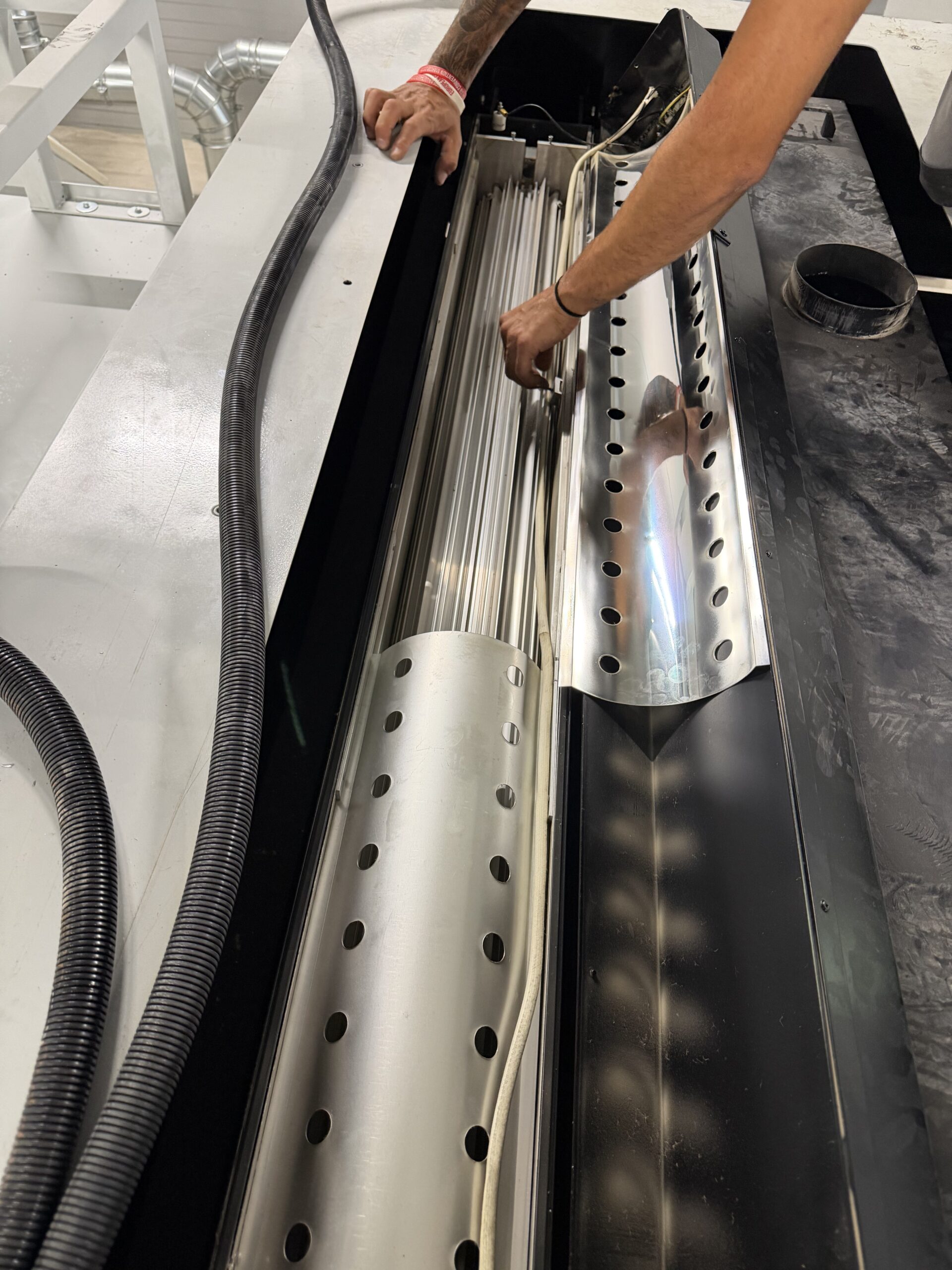 Hands-on work on the open lamp housing of a UV system for marble